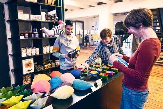 Besucher kaufen im Museumsshop vom Hafenmuseum Speicher XI ein.