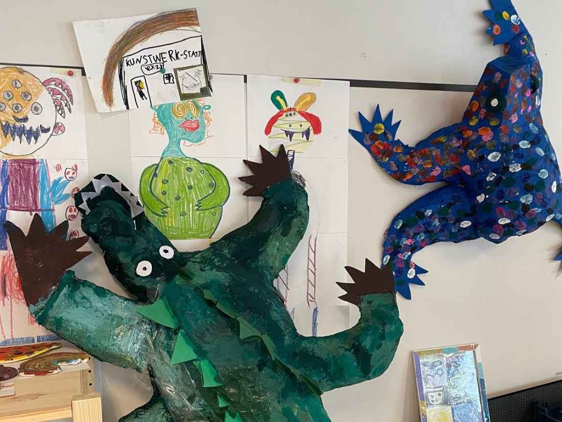 Bunte Bilder und selbst gebastelte Skulpturen hängen an der Wand der Kinderkunstwerkstatt Bunte Bilder und selbst gebastelte Skulpturen hängen an der Wand der Kinderkunstwerkstatt