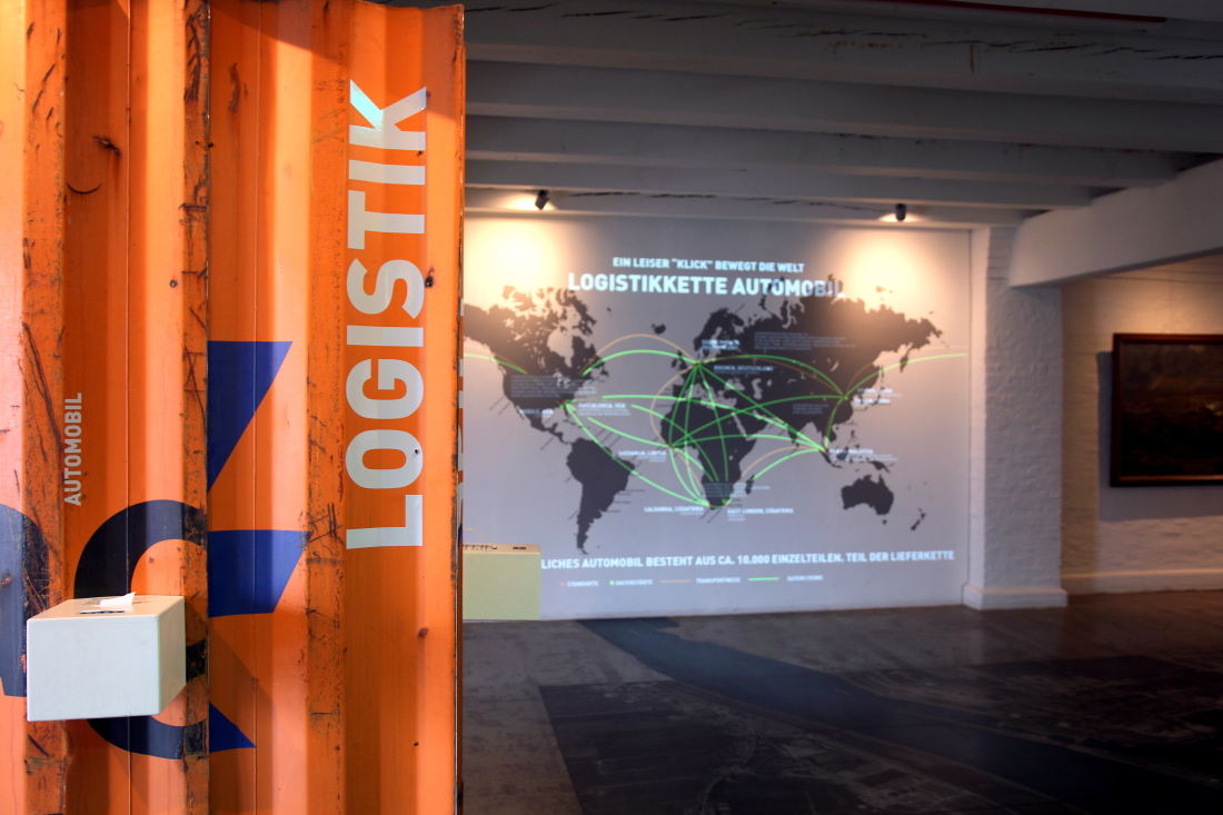 Logistikspiel im Hafenmuseum mit Logistik-Weltkarte im Hintergrund