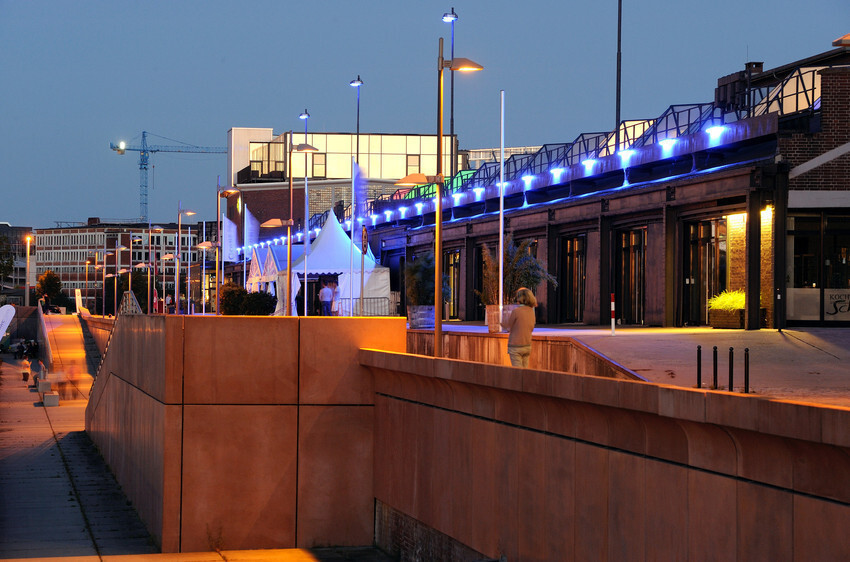 Die Fassade des Schuppen 2 am Europahafen bei abendlicher Beleuchtung.
