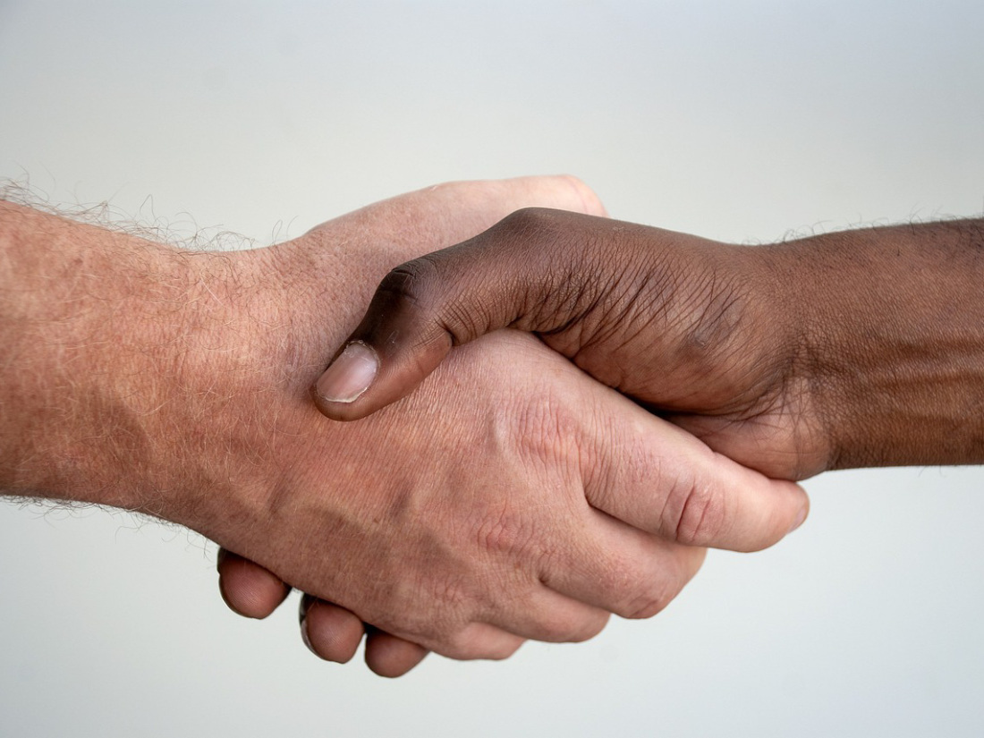 Zwei Personen geben einander die Hand, wobei nur die Hände zu sehen sind Zwei Personen geben einander die Hand, wobei nur die Hände zu sehen sind
