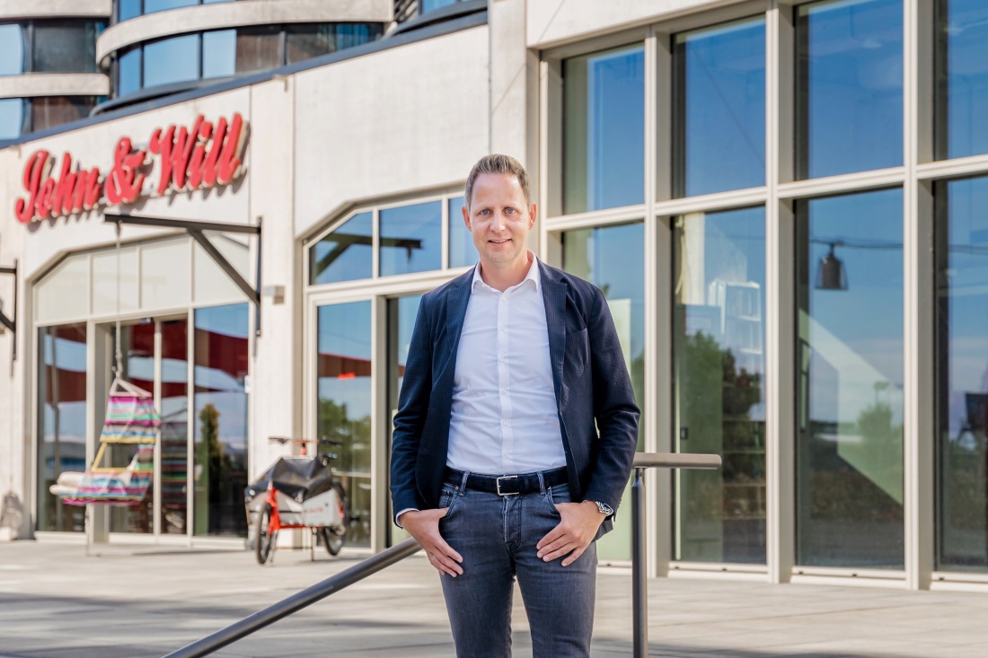 Johannes Aderholz, Geschäftsführer der Überseeinsel GmbH steht vor dem Eingang des John & Will Silo-Hotels auf der Überseeinsel in der Überseestadt.