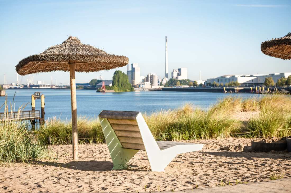 Der Strandpark Waller Sand mit Sandstrand, Sonnenschirmen und Blick auf das Hafenbecken
